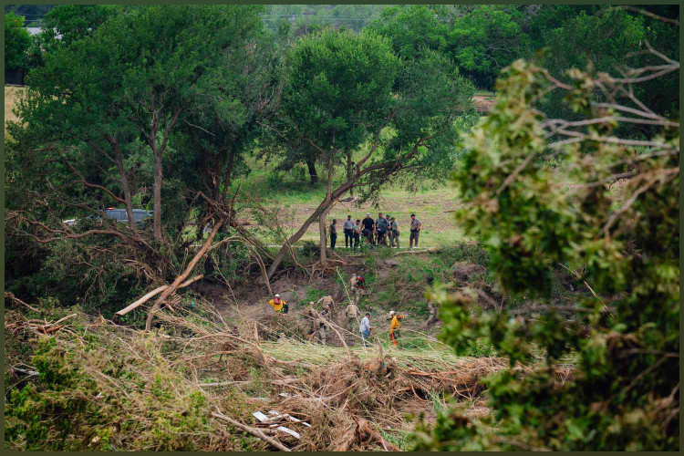 Law enforcement officials recover a body along the Guadalupe River in Kerrville, Texas on Sunday, July 6, 2025. 