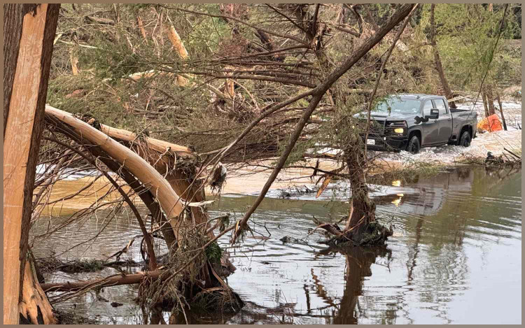 HUNT, TEXAS JULY 6: A vehicle crosses flood waters in Hunt Sunday, July 6, 2025. 